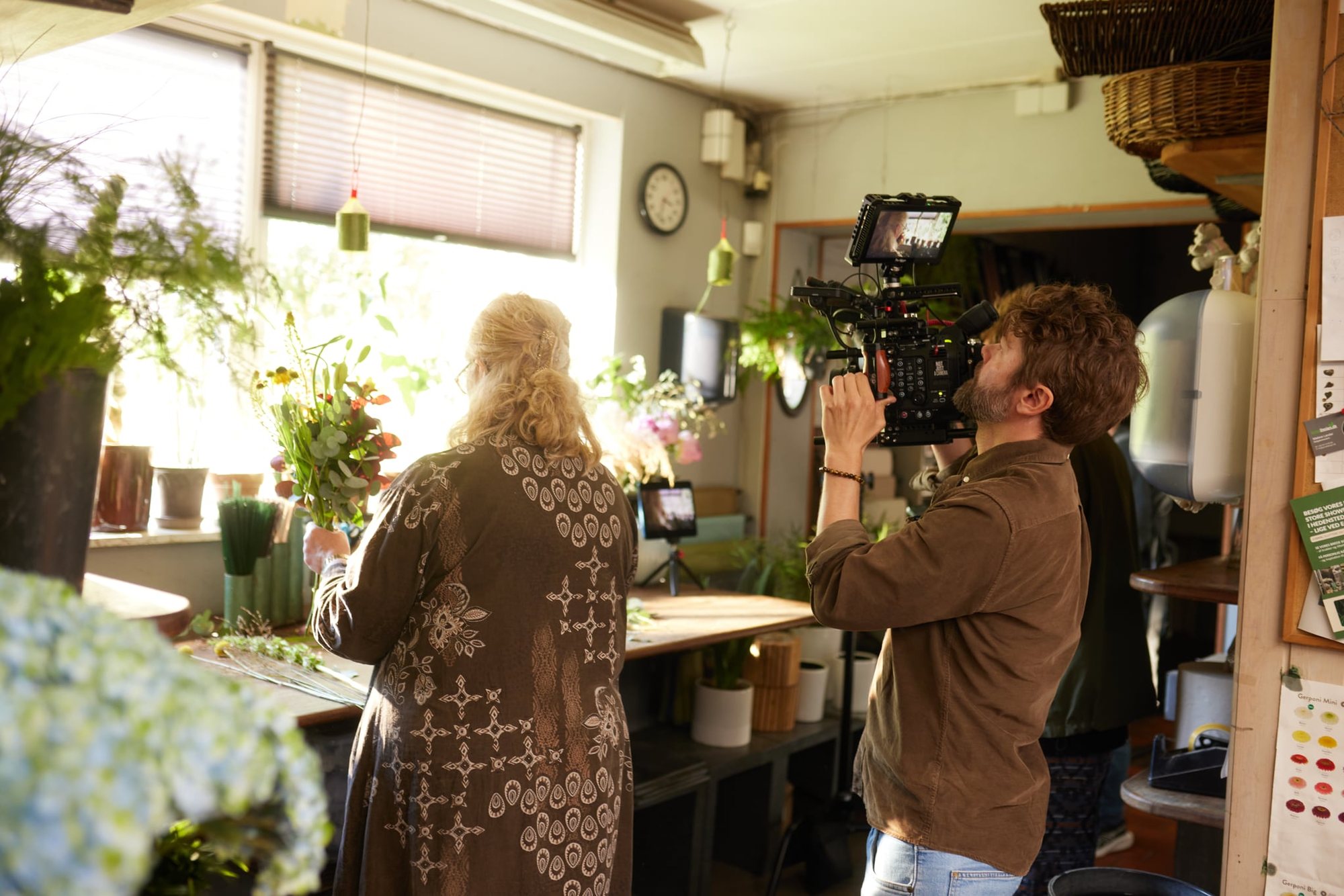 Filmholdet optager helt tæt på blomsterhandleren ved vinduet