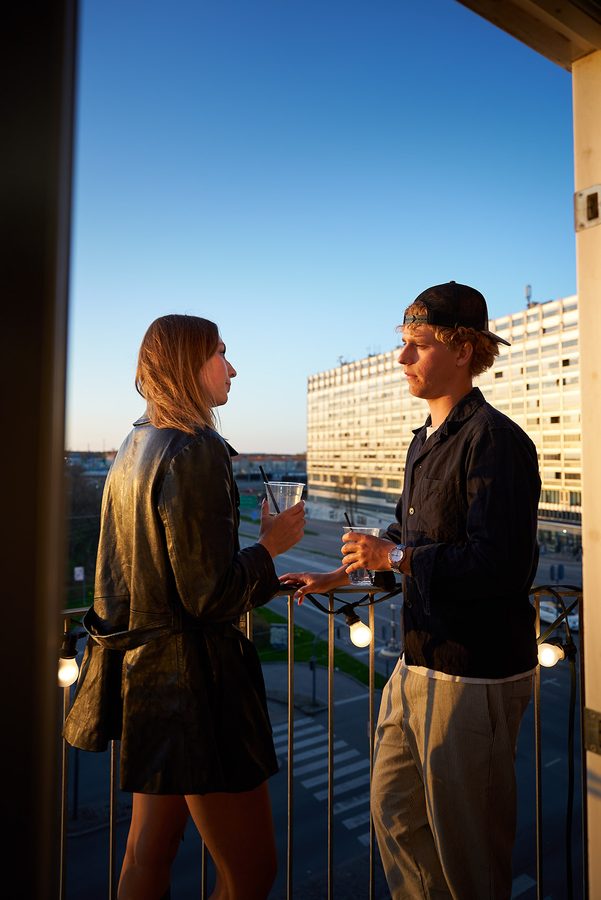 To gæster i samtale på altanen i den blå time