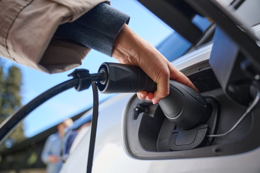 Hånd sætter ladestik i elbilen