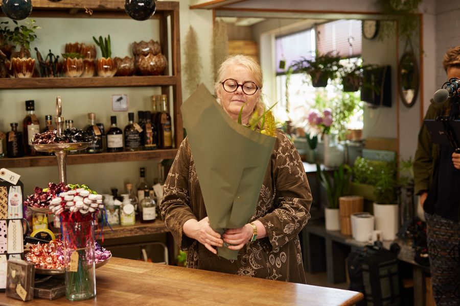 Blomsterhandler med buket bag disken